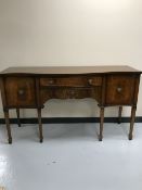An inlaid mahogany Regency style serpentine fronted sideboard