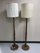 A pair of carved oak standard lamps with shades