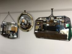 Two early twentieth century frameless bevel edged mirrors together with a cream and gilt porthole
