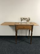 A mid twentieth century Singer electric sewing machine in a walnut table