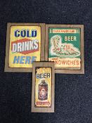 Three advertisements on pine boards, 'cold drinks here',