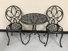 A cast metal patio table and two chairs