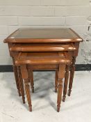 A nest of three inlaid yew wood tables