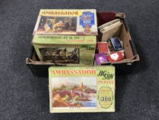 A box containing vintage jigsaws, card games, cigarette cards and albums,
