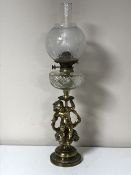An antique oil lamp with glass chimney and shade on a cherub base CONDITION REPORT: