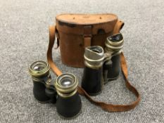A pair of leather cased field glasses and one other pair