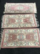 Four fringed Chinese rugs on pink ground