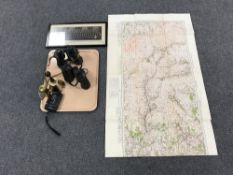 A tray containing two pairs of field glasses, brass hand bell and miniature miners lamp,