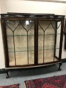 An early 20th century display cabinet on claw and ball feet