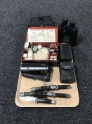 A tray consisting of cased binoculars, cameras, two miniature knives in the form of samurai swords,