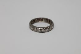 An early twentieth century diamond eternity ring in white metal, size K, 3.3g.
