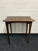 A shaped oak occasional table on reeded legs