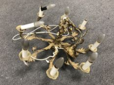 A brass eight way light fitting with cherub decoration