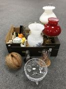 A box containing converted brass oil lamps with chimneys and shades,