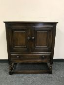 An Ercol dark elm double door cupboard,