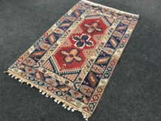 A fringed woollen rug of geometric design