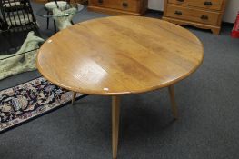 ** LOT DESCRIPTION CHANGE ** An Ercol light elm flap sided circular dining table