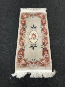 A cream fringed Chinese hearth rug