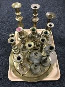 A tray containing a quantity of brass candlesticks,
