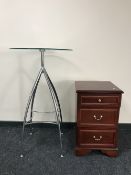 A three drawer bedside chest together with a glass top poser table on a chrome base
