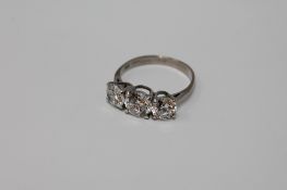 An 18ct white gold three stone dress ring, size N.