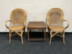 A pair of wicker armchairs and a lamp table