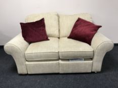 A two seater settee upholstered in a beige fabric,