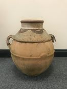 A large terracotta twin handled urn with metal mounts