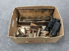 A box containing a pair of Tasco binoculars, vintage flat irons,