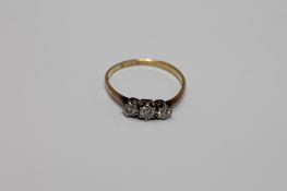 An 18ct gold three stone diamond ring, size N/O, 1.5g.