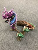 Three contemporary figures of dragons on wooden stumps and a figure of an Iguana