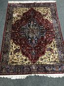 A fringed Persian rug on red ground with central medallion,