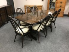 An Ercol dark elm refectory table, 88 cm x 182 cm, together with eight chairs.