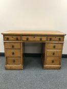 An antique pine knee hole desk fitted ten drawers