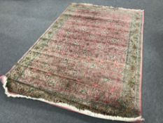A Kashmir fringed rug on pink ground CONDITION REPORT: This measures 268cm by 180cm.
