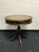 A mahogany circular leather topped drum table