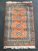 A Persian rug of geometric design on peach ground 78 cm x 120 cm