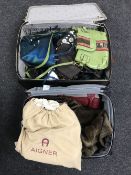 A luggage case containing a quantity of assorted ladies handbags, including a Rich's fur handbag,