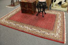 An Indian carpet on red ground 240cm x 171cm