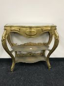 A shaped gilt marble top three tier console table