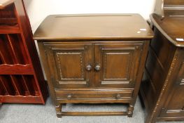 An Ercol double door cabinet fitted with a drawer,