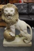 An impressive pair of lion statues standing on ball plinths,