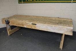A large wooden work bench with vice