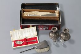 A collection of sterling silver, including a pair of squat candlesticks, silver backed hand brush,