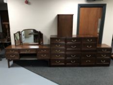 A nine piece G plan bedroom suite in a mahogany finish with brass drop handles,