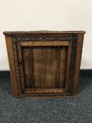 An antique carved oak wall cabinet