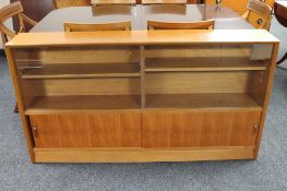 A mid twentieth century teak sliding glass door bookcase