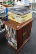 An audio cabinet in a mahogany finish together with small quantity of cds, dvds,