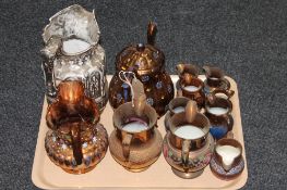 A tray containing eleven copper lustre jugs,