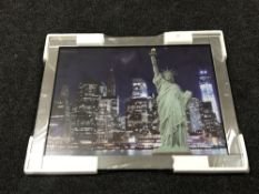 A framed print of the Statue of Liberty in an all glass frame